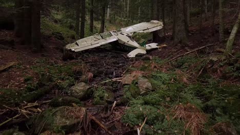 Drone-dolley-shot-over-a-crashed-airplane-in-a-dense-forest-in-Rhone-Alpes-region-in-France