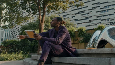 Black-man-with-touchpad-looking-for-inspiration-outside-in-park