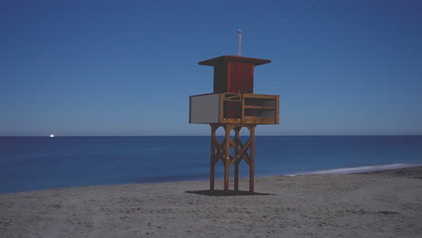 Small-lifeguard-tower-at-night,-time-lapse-on-the-Mediterranean-coast