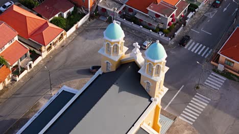 Aerial-ascending-establishes-pastel-orange-chapel-towers-of-Santa-Famia-Otrobanda-Curacao