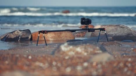 A-camera-on-the-slider-filming-a-timelapse-set-up-on-the-rocky-beach