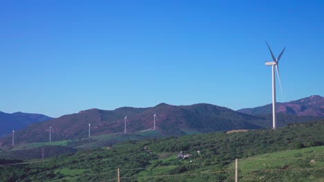 Hügel-In-Andalusien-Mit-Mehreren-Windkraftanlagen,-Die-An-Einem-Windigen-Tag-Mit-Klarem-Blauen-Himmel-In-Betrieb-Sind