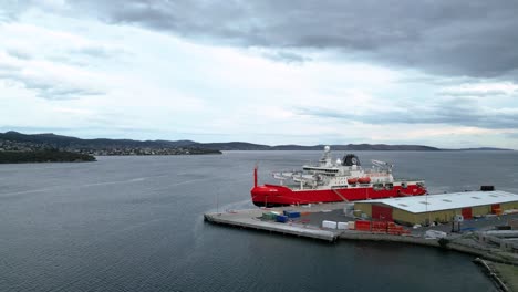 RSV-Nuyina-Australia-Icebreaker-at-port-push-in-wide-sky-drone-shot-50fps