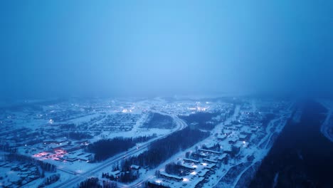 High-Aerial-4K-Sunrise-Blue-Hour-Morning-Cinematic-4K-Blizzard-Snowfall-Foggy-Glowing-Drone-Shot-of-Arctic-Winter-Community-Isolated-Nunavut-Mining-Village-Hub-of-the-North-Thompson-Manitoba-Canada