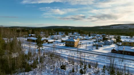 Skorped,-sweden,-with-houses-and-trees-covered-in-snow-during-winter,-aerial-view