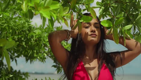 An-Indian-girl-in-a-vibrant-red-bikini-facial-close-up-savors-the-beauty-of-a-Caribbean-tropical-beach