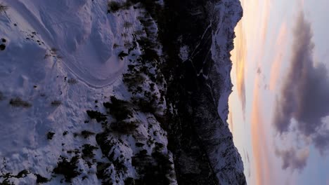 Luftaufnahme-Des-Dramatischen-Sonnenuntergangshimmels-Und-Der-Silhouette-Einer-Schneebedeckten-Landschaft-Im-Hintergrund