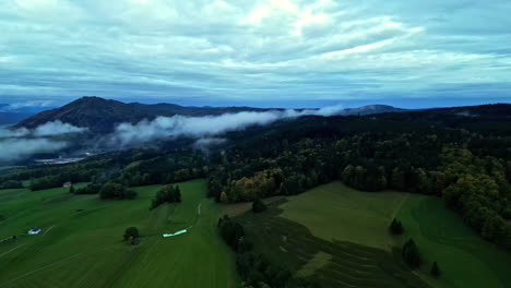 Aerial-view-backwards-over-the-foggy-countryside-of-Attersee,-fall-day-in-Austria