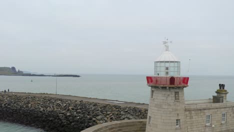 Aerial-dynamic-shot-captures-Howth-lighthouse,-ending-with-a-close-up-of-the-lantern