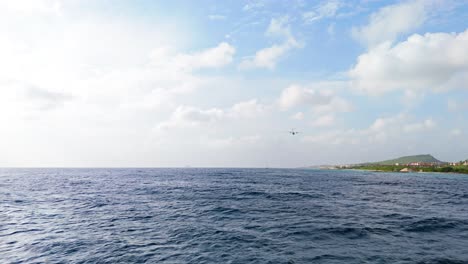 Coastguard-Dash-8-plane-flying-low-overhead-above-deep-blue-Caribbean-ocean-off-coast-of-Curacao