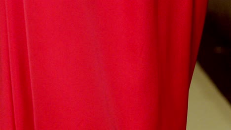 Con-Un-Vestido-De-Tela-Rojo-Fluido,-Una-Impresionante-Modelo-Se-Arregla-El-Cabello.