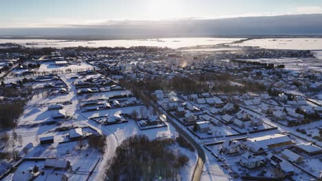 Cinematic-drone-shot-of-city-of-Silute-housing-society-landscape-in-winter-at-sunset,-Lithuania