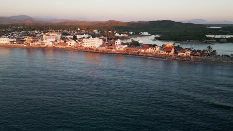 Drone-reveal-Barra-de-Navidad-in-Jalisco-Mexico-pacific-coastline-at-sunset-surf-town