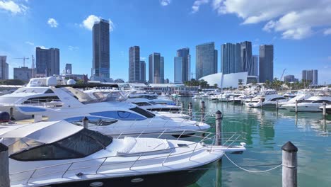 Luxurious-boat-harbor-in-Miami-with-city-skyline-and-skyscraper,-pan-right
