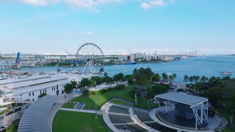 Drone-rising-over-Bayfront-Park-in-Miami,-Florida,-harbor-and-ferris-wheel
