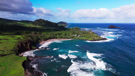 Filmische-Drohnenaufnahme-Von-Riesigen-Wellen,-Die-An-Einem-Sonnigen-Und-Heißen-Tag-Am-Strand-Von-Hawaii-Gegen-Die-Felsen-Krachen