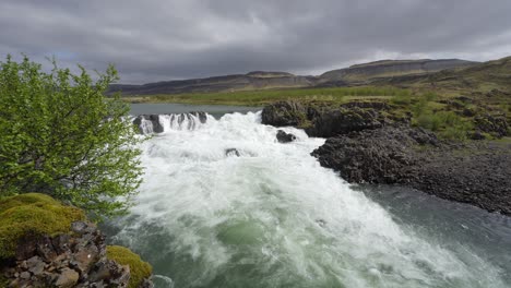 The-stunning-Nordic-landscape-with-a-roaring-waterfall-and-mountains-in-the-distance