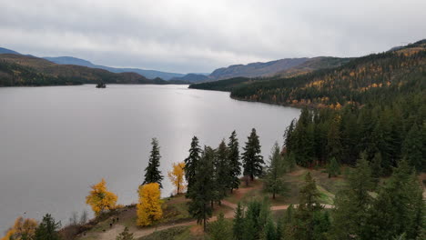 Niskonlith-Lake,-Kanada:-Herbstreflexionen-Und-Neblige-Berge