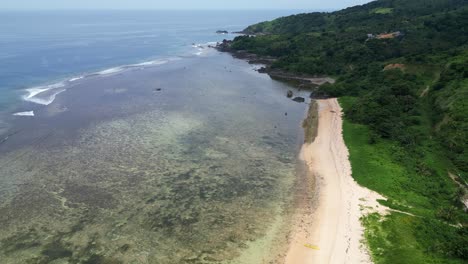 Puraran-baras-with-clear-waters,-coral-reefs,-sandy-beach-and-lush-greenery,-aerial-view