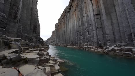 A-crystal-clear-river-flowing-through-magnificent-Studlagil-cliffs-in-Iceland