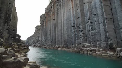 Studlagil-turquoise-river-flowing-through-a-spectacular-canyon-of-basalt-rock-formations