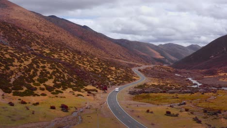 La-Autocaravana-Circula-Por-Una-Carretera-Sinuosa-Con-Profundos-Valles-Inclinados-Salpicados-De-Arbustos-Verdes.