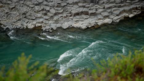 Blick-Hinunter-Auf-Einen-Kristallklaren-Bach,-Der-Durch-Ein-Felsiges-Tal-In-Island-Fließt