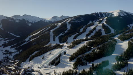 Aerial-Drone-Copper-Mountain-Colorado-Ikon-Epic-Pass-winter-spring-sunny-first-light-sunrise-morning-sunset-half-pipe-chairlift-ski-runs-center-village-slowly-circle-right-motion-upward