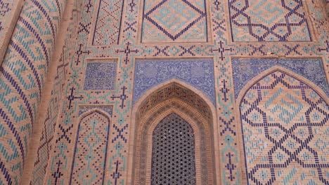 detailed-tling-and-islamic-artwork-on-arched-windows-and-doorways-of-historic-mosque-in-Samarkand,-Uzbekistan-along-the-historic-Silk-Road