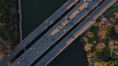 Cinematic-aerial-shot-of-cars-and-traffic-crossing-highway-bridge-over-river