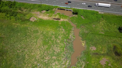 Aerial-over-Mudgeeraba-creek,-parkland-and-M1,-Gold-Coast,-Queensland,-Australia