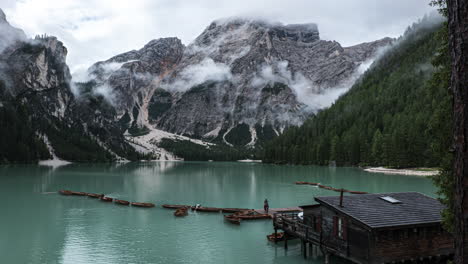 Small-tourist-boats-floating-on-Braies-lake-time-lapse-with-mist-creeping-around-Dolomites-alpine-mountain-valley