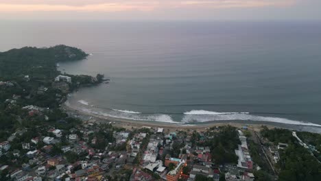 Panoramic-aerial-overview-of-long-crashing-waves-on-bay-off-coast-of-Sayulita-Mexico
