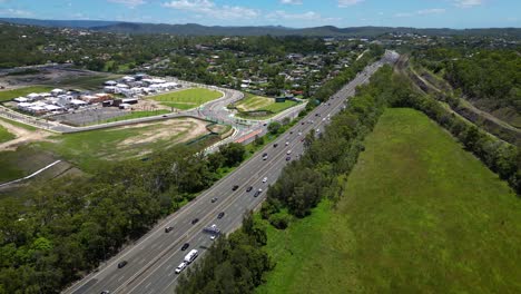 Forward-moving-aerial-view-over-Worongary,-M1,-Skyridge-and-rail-line-near-Skyridge-development,-Gold-Coast,-Queensland,-Australia
