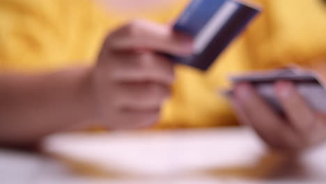 Close-up-of-an-individual-who-is-choosing-a-credit-card-and-handing-one-to-another-person-on-the-other-side-of-the-frame