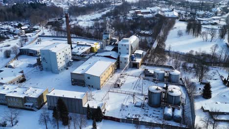Drone-view-industrial-building-of-electric-utility-company-in-city-of-Silute-in-winters,-Lithuania