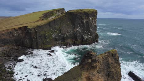 The-beautiful-Icelandic-Valahnúkamöl-coastline-with-rocky-cliffs-and-high-waves-rolling-in-from-the-ocean