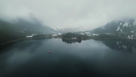 Aerial-wide-panorama-of-a-vessel-anchored-in-middle-of-foggy-mountains-of-Alaska