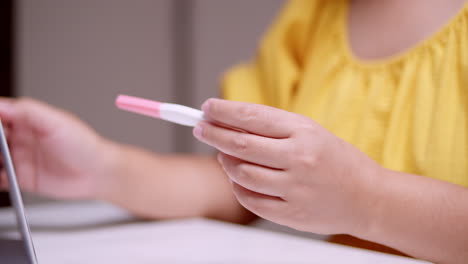An-expectant-woman-is-holding-a-pregnancy-test-while-counting-the-days-and-months-prior-to-her-possible-delivery-due-date
