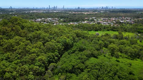 Right-to-left-aerial-view-over-Fox-Hill-Reserve-looking-towards-Surfers-Paradise,-Gold-Coast,-Queensland,-Australia