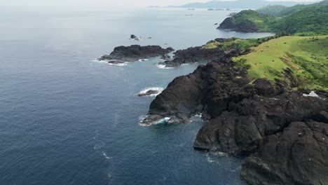 Rugged-coastline-and-green-fields-in-baras,-catanduanes,-philippines,-serene-tropical-landscape,-aerial-view