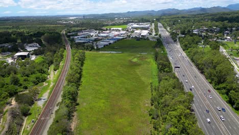 Forward-moving-aerial-view-over-Worongary-industrial-area,-M1-and-rail-line-near-Skyridge-development,-Gold-Coast,-Queensland,-Australia