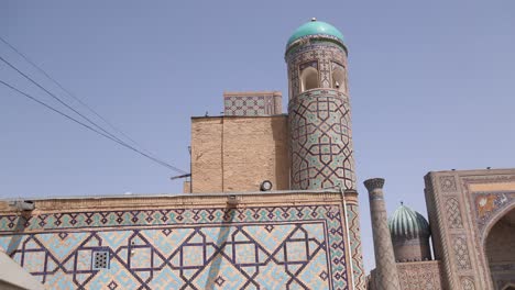 tall-minaret-with-bright-blue-dome-in-Registan-square-in-Samarkand,-Uzbekistan-along-the-historic-Silk-Road