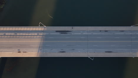 Aerial-of-lonely-person-crossing-bridge-then-cars-begin-to-drive