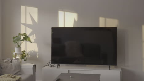 Zeitraffer-Des-Lichts,-Das-Sich-Vom-Fenster-Zum-Wohnzimmer-Mit-Fernseher-Und-Minimalistischem-Design-Bewegt