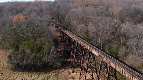 Tight-Aerial-Shot-Of-Train-Tracks-Running-off-the-Pope-Lick-Trestle-and-into-the-Woods-in-Louisville-Kentucky