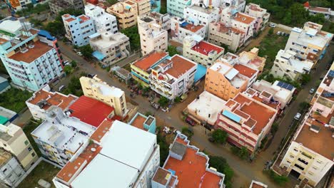 Residential-district-shops-and-orange-open-roof-tops-of-Tiruchirappalli,-city-establishing-aerial-overview