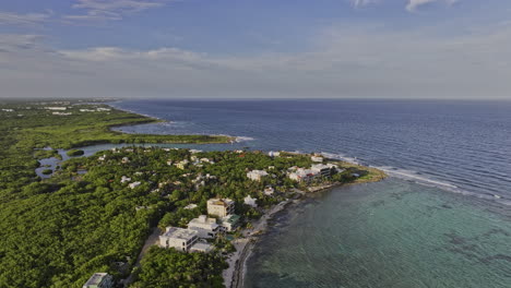 Akumal-Mexico-Aerial-v5-cinematic-drone-fly-up-and-over-seafront-ocean-views-resorts-and-vacation-homes-capturing-coastal-landscape-featuring-Yal-Ku-eco-park---Shot-with-Mavic-3-Pro-Cine---July-2023