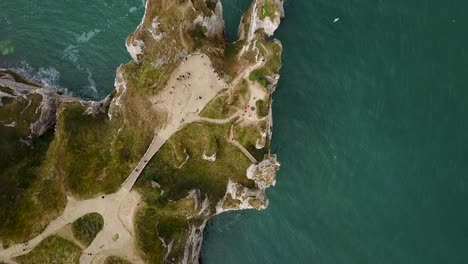 Flying-above-the-pathways-that-lead-to-the-rocky-arch-of-Etretat-on-the-coastline-of-France