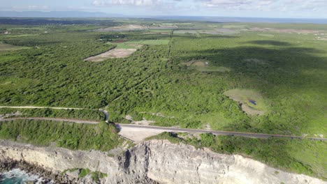 Massive-jungle-and-highway-road-in-Guadeloupe,-high-angle-drone-view